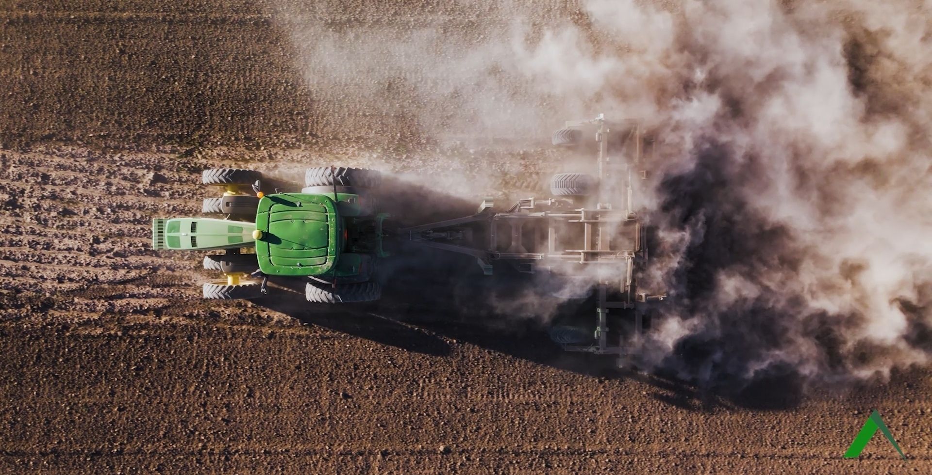 APEX Hyperdisc T Series working a field behind a tractor at speed, heavy dust